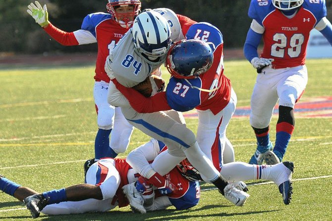 T.C. Williams linebacker Kyreem Walton (27) tackles West Potomac receiver R. Marquis Saldana during the Titans’ 24-14 victory on Nov. 9.