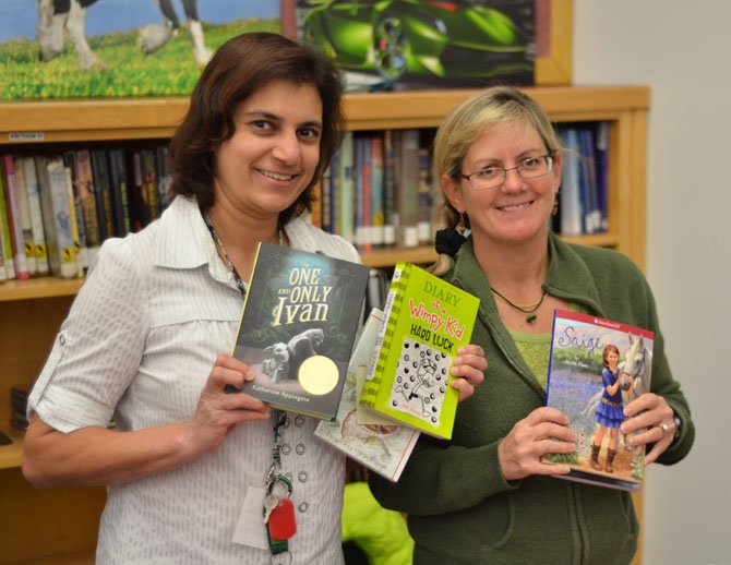 From left, Shermin S. Kapadia and Joanne Lyons, members of the Herndon PTA helped sell books at the Herndon Elementary fall book sale.