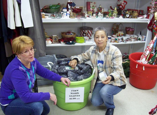 Sheron Flynn, store manager of Lorton’s Attic, works with volunteer Audrey Silvia of Springfield to organize a donation of gloves.  