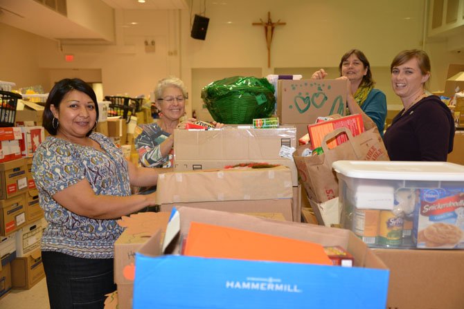 Cornerstones staff and volunteers accept food donations and prepare the boxes the night before the Thanksgiving food distribution at St. John Neumann Catholic Church in Reston. From left: Minnie Orozco, Urgent Needs and Life Skills Program Manager, Gail Greenberg, Board Member and volunteer, Susan Alger, Volunteer and Resource Manager, Embry Rucker Community Shelter, and Alacia Earley, Volunteer and Drives Manager.