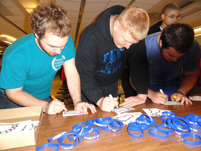 Signing their anti-bullying footprints are (from left) Andrew Orvedahl, Alex Brunner and Kyle Wilkinson.
