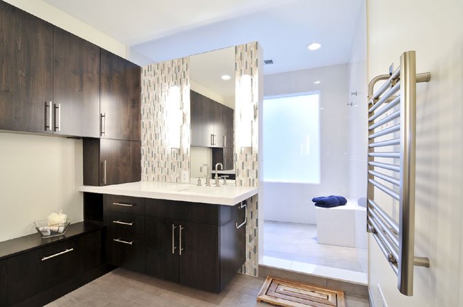 This Great Falls bathroom by Sun Design, Inc. is furnished with cabinetry made from alder wood, Caeserstone counter tops and porcelain tile walls. 