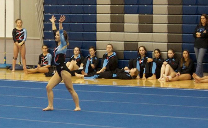 Senior Co-Captain Casey Howard performs her floor routine while the Marshall team looks on.