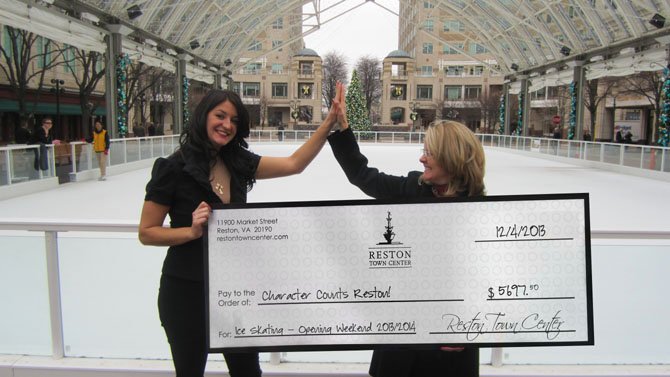 Manager of Reston Town Center Ice Skating Pavilion, Marissa Marwell, congratulates Cate Fulkerson, president of Reston Character Counts! Coalition on receiving a record-breaking donation of $5,697.50 from 50 percent of the rink’s opening weekend proceeds. 
