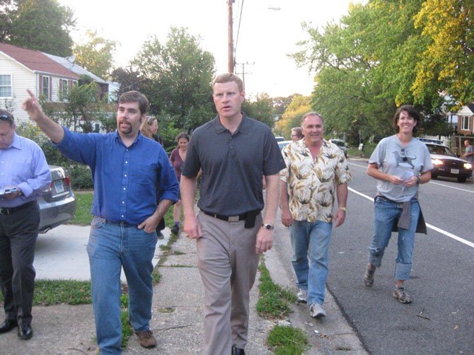 Supervisor Jeffrey McKay (D-Lee) gets a sidewalk level view of the neighborhood at the Jefferson Manor walking town meeting with civic association president Chris Soule.