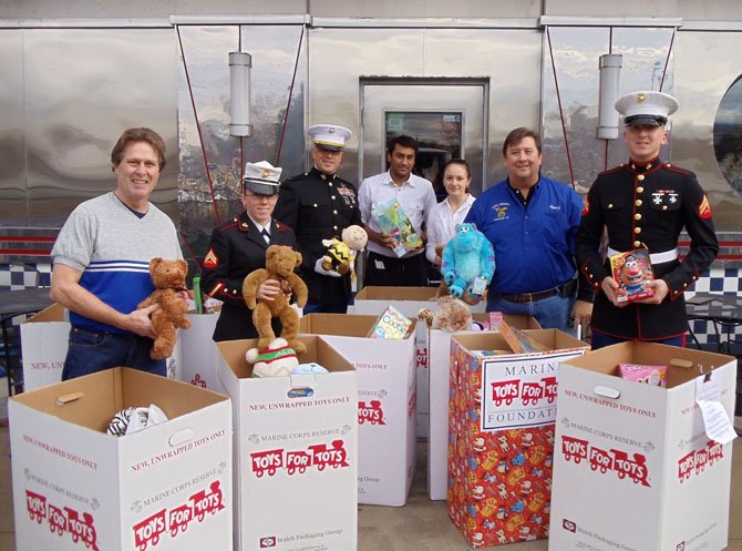 From left are Clifton’s Jim Chesley, three Marines, two servers from the Juke Box Diner and Gary Binge with the donated toys.