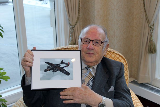 Ray Gilbert sits at the Fairfax near Fort Belvoir with a picture of a P-61, on which he served as a radar operator in World War II.