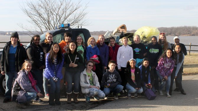 Volunteers from South County Middle School, including many members of Cadet Girl Scout Troop 340 of Lorton, pose in front of the trash they collected at Mason Neck State Park. 
