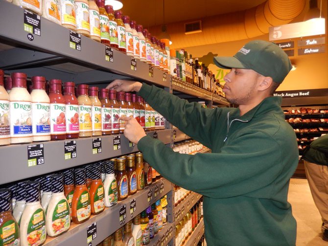 Grocery Manager Alonzo Jordan checks the price tags on the salad dressings.
