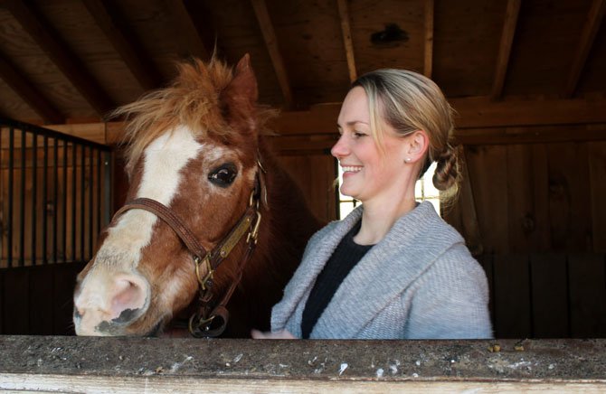 Peaches, a horse of the Northern Virginia Therapeutic Riding Program, stands with Kelsey Gallagher, NVTRP interim executive director. 