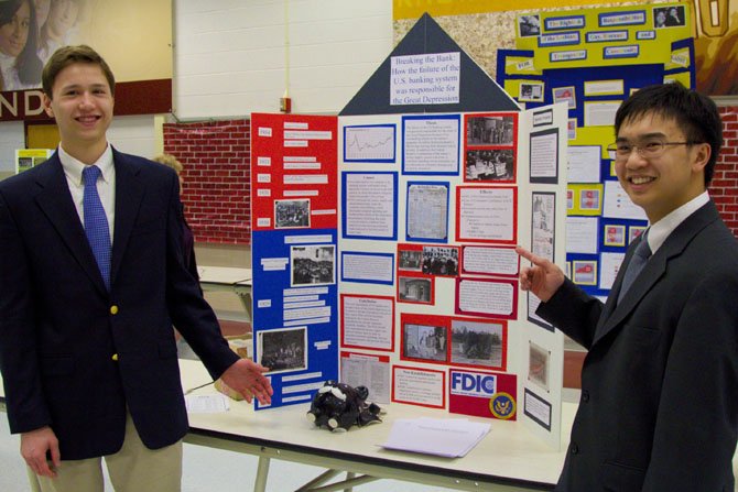 Robert Marchibroda (left) and Nick Phan share their Senior Group Exhibit. They are interested in economics and spent two months on research for their project. This is their first time entering and their "Breaking the Bank: How the failure of the U.S. banking system was responsible for the Great Depression" display took third place.