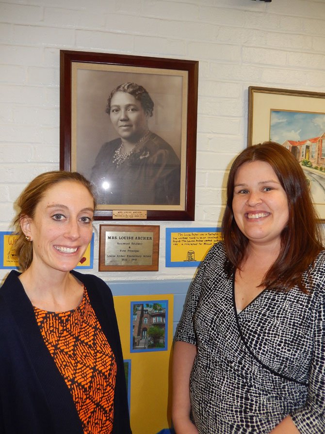 (From left) are teachers Lauren Wagner and Kris Beurmann under a portrait of Louise Archer.