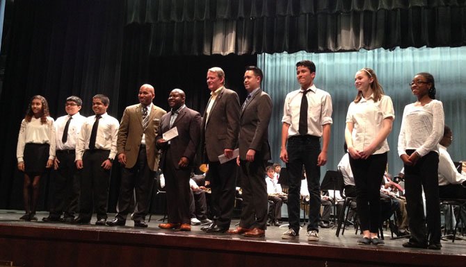 First Night board member Kerry Donley, fifth from right, poses for a photo with ACPS band and orchestra members after presenting a check for $3,000 to support the music programs of Francis Hammond and George Washington Middle schools and T.C. Williams High School.