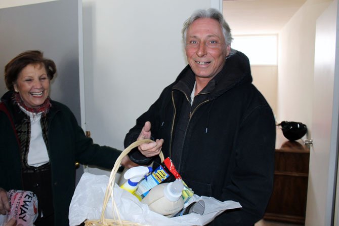 David Vernon recently moved into the FACETS TRIUMPH II Housing program, which houses individuals who were previously chronically homeless. In this picture, Elsbeth Hoff of the Gracing Spaces program greets Vernon with a donation basket at the housewarming celebration welcoming 18 previously homeless clients into their homes.