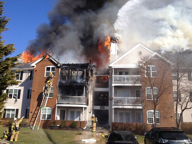 City of Fairfax firefighters rescue occupants and attack the blaze as smoke and fire pour out of the building.
