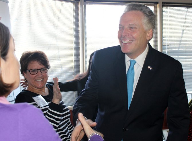 Gov. Terry McAuliffe greets an attendee of a Medicaid expansion roundtable discussion at Alexandria Neighborhood Health Services in Arlington on March 20. 