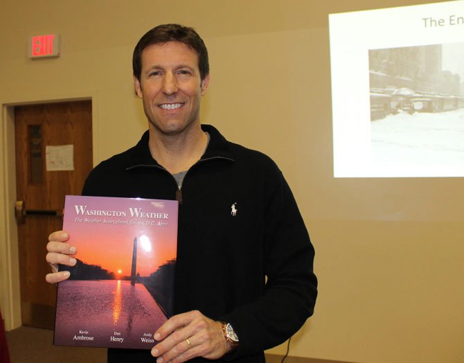 Kevin Ambrose holds his book “Washington Weather” at a meeting of the Burke Historical Society on March 30.
