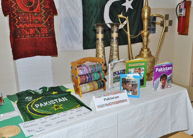 A table display for Pakistan included reference books on the culture, a World Cup jersey, brightly colored jewelry and other collectibles and decorations. Clothing and the flag of Pakistan adorned the wall behind.