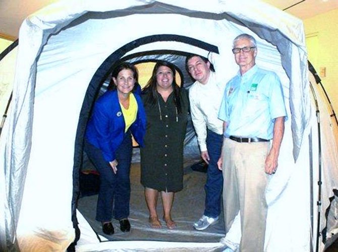 Wayne Chiles, right, poses with a tent used in disasters provided by ShelterBox USA.