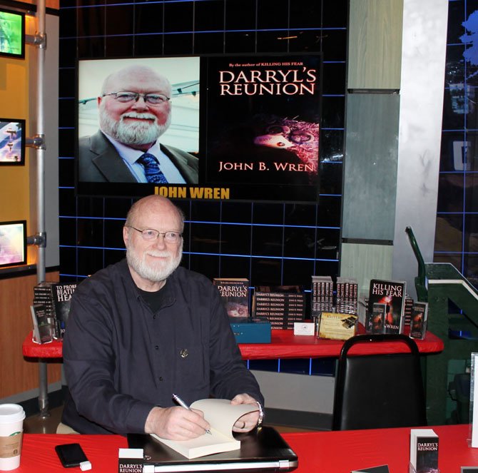 John B. Wren, who lives on the outskirts of Burke in Bonnie Brae, signs a copy of his book “Darryl’s Reunion” at a book fair for crime writers at the National Crime and Punishment Museum in Washington, D.C. on April 12.