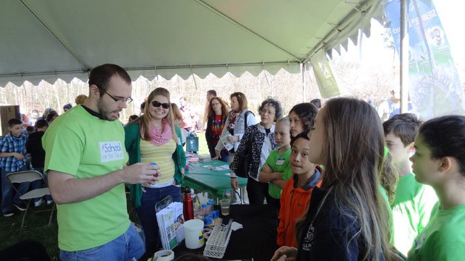 Activity table at the iSchool for the Future Environmental Action Showcase at George Mason University: Adam Fleming and Caitlin Tucker work with visiting students.
