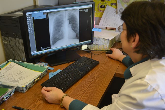 Fairfax County Health Department's primary care TB physician Dr. Barbara Andrino examines a patient's X-ray who is latent for tuberculosis. 