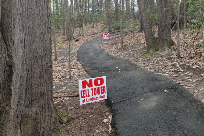 Signs opposing the proposed cell phone tower line the path leading to the pool in the Landings community of the Burke Centre Conservancy.