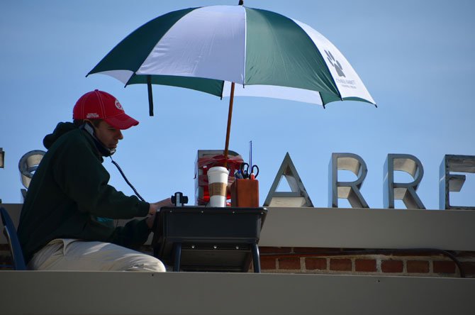 Charles Barrett ES Principal Seth Kennard works from on top of the school roof last Friday as a PBIS reward for the students.
 
