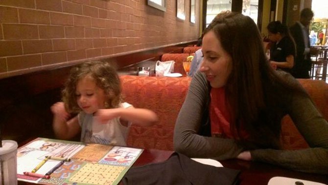 Speech-language pathologist Erin Weiner holds a therapy session with a young patient in a natural environment.
