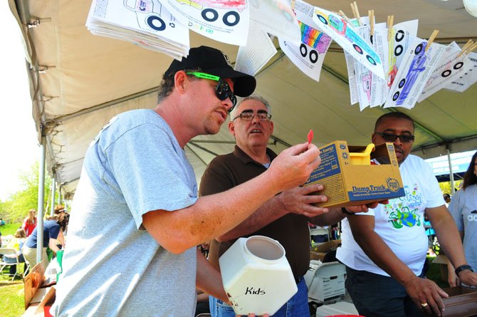 Virginia Paving Environmental Manager Chris Monahan reads out the winning ticket for the prize at the annual Alexandria Earth Day Festival at Ben Brenman Park. With Monahan are Brendan Morris and Diego Ruiz.
