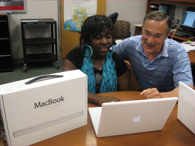 Laptops for Success program founder Marie Assir and former Principal Bruce Butler in a photo from 2009, play with the newest Macbook model.