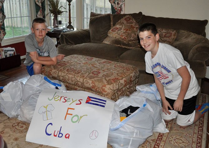 From left, Thomas and Jack with many bags of donated baseball clothing items.