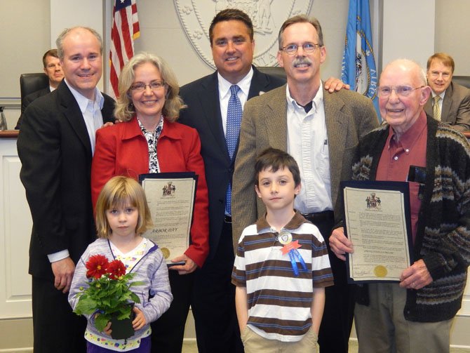 Making a Fairfax City Council proclamation are (back row, from left) Environmental Sustainability Committee members Tim Killian and Judy Fraser, Mayor Scott Silverthorne and Community Appearance Committee members Kirk Holley and Don Lederer; and (front row, from left) Abby Killian and Thomas Simione. (In background are Councilmen Jeff Greenfield and David Meyer).
