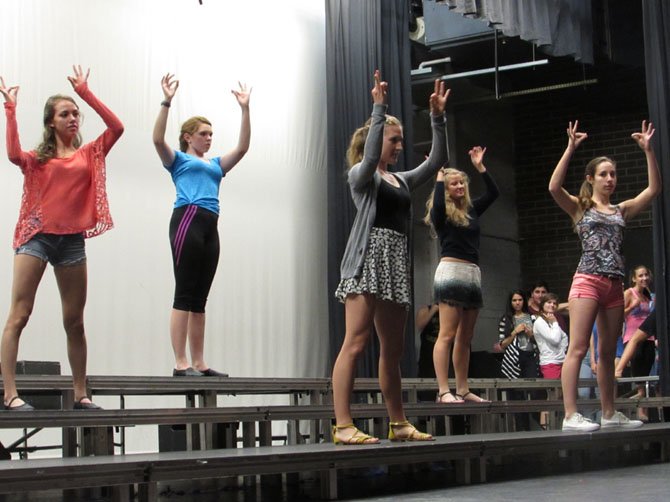 An ensemble of female singers practice their choreography with style.