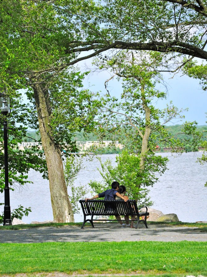 A couple enjoys a quiet moment at Founders Park along the waterfront in Old Town Alexandria.
