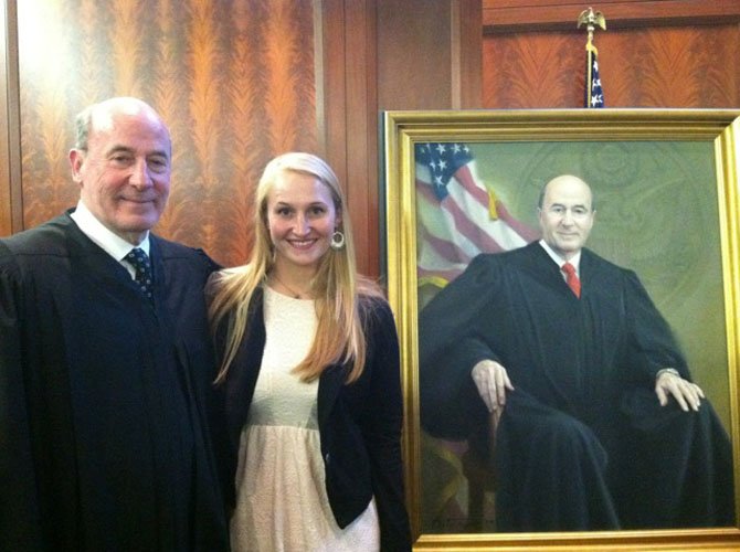 Judge Roger W. Titus poses with his granddaughter, Emily Titus, at the May 8 portrait ceremony at the U.S. District Court for the District of Maryland. Emily was among the more than 100 guests who witnessed “the hanging of the judge.”