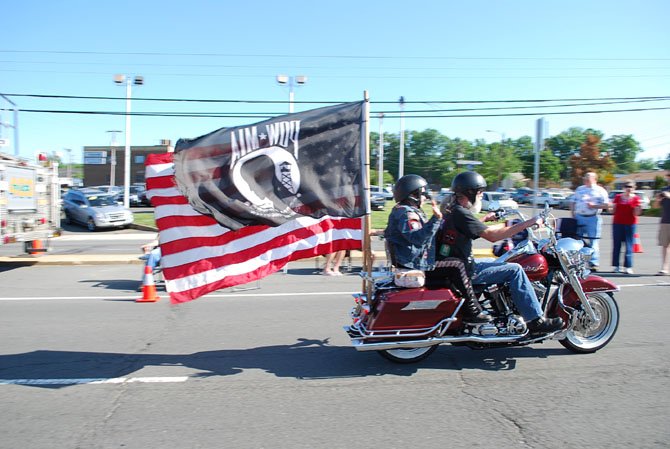  A motorcycle of the Ride of the Patriots blazes by and parades both an American Flag and a Prisoners of War and Missing in Action flag Sunday, May 25.
