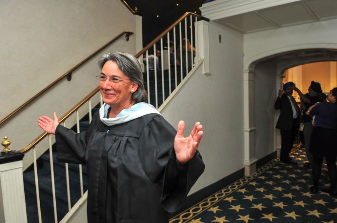 Retiring Churchill High School teacher Gayle Jones directs parents up the stairs for seating at the 2014 graduation.