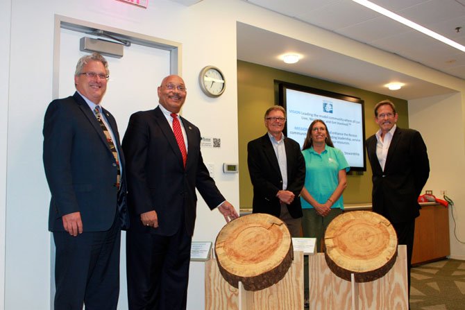 County Director of Park Authority Kirk W. Kincannon, Park Authority Board Chairman Bill Bouie, Fairfax County Tree Commission Chairman Robert Vickers, Reston Association Parks and Recreation environmental resource manager Claudia Thompson-Deahl and RA Chairman Ken Kneuven in front of the tree cookie.