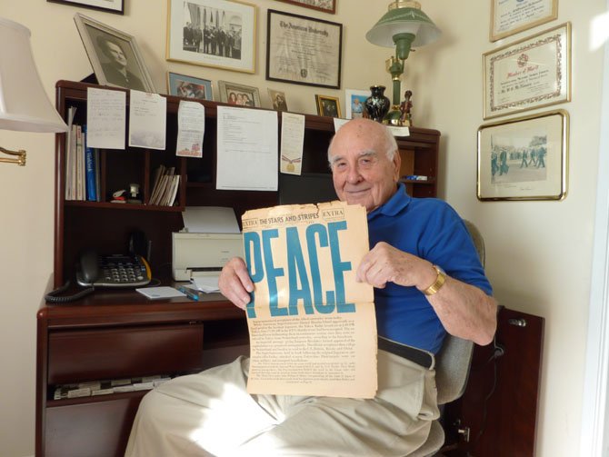 Bill McNamara holds a copy of the Stars and Stripes newspaper dated Aug. 14, 1945.
