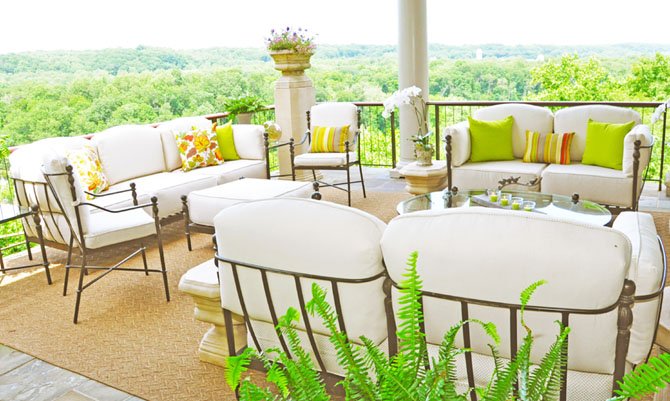 Alexandria, Va., based designer Anna Kucera chose neutral, weatherproof fabrics for the seat cushions on this Great Falls porch, which she accented with vibrantly colored throw pillows. 
