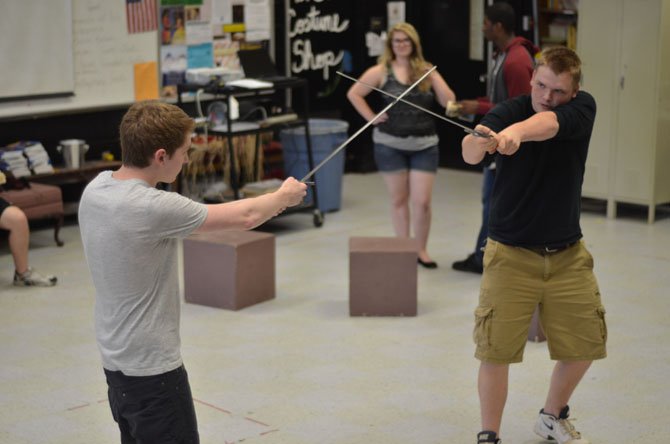 Herndon High students Hunter Robinson and Nathan Han cross swords in a rehearsal for the upcoming production of Hamlet. Robinson has the role of Hamlet, and Han has the role of Laertes.