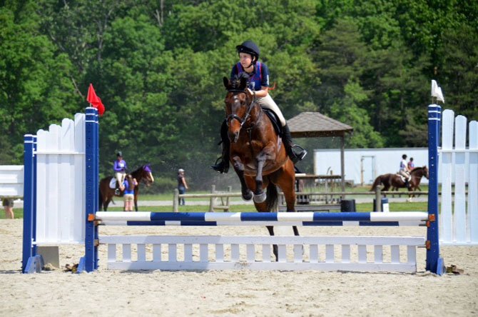 Cassie Picard and her pony jumping over a hurdle during a jumping rally in Richmond.