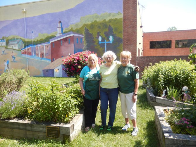 (From left) Ayr Hill Garden Club President Pam Weiss, children’s garden co-founder Anna Marie Mulvihill and club Treasurer Nancy Madden stand in the children’s Discovery Garden they help maintain.