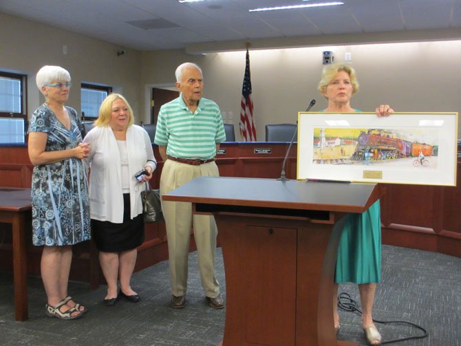 Mary Ellen Larkins, Lu Cousins, Harris Miller and Grace Rooney of the Vienna Arts Society present to the Town of Vienna a print of Miller’s painting, in memory of late mayor M. Jane Seeman.