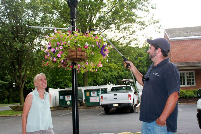 Joanne Shumpert, owner of Landscape Design Associates, chose the petunias that George Benza, owner of SGB Land Management, maintains during the early hours.