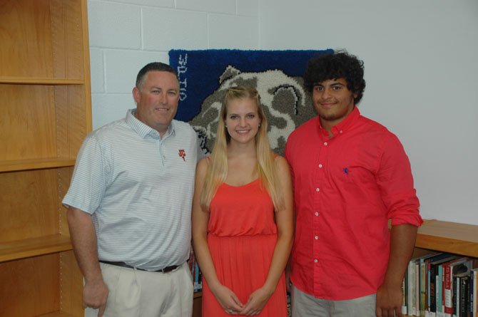 Sean Casey, father of Jackson Casey, presents scholarship awards to Clare Spitnale and Darien Pickett.
