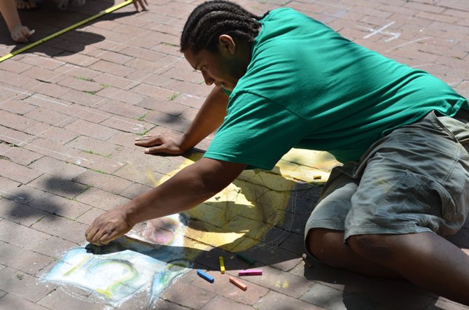 Belmin Rivera, a 2011 graduate of Reston South Lakes high school works on  his chalk mural on Saturday at Lake Anne Plaza for the June chalk festival.