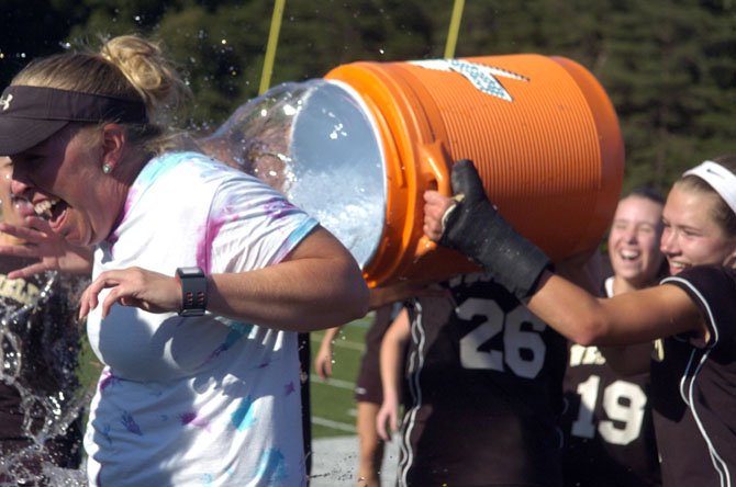 Westfield girls’ lacrosse coach Katie Ruch, left, receives a celebratory bath after the Bulldogs won the 6A state championship on June 15.