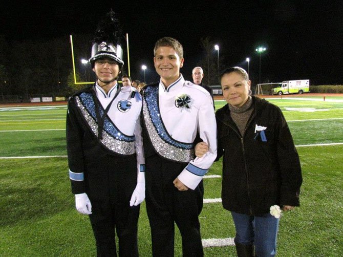 Julio Mendez (center) with his brother, Alexander, and their mom, Goldwyn Cabrera, on Marching Band Senior Night.
